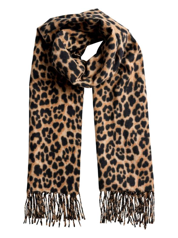 Écharpe beige à motifs animaliers noirs avec des franges tressées